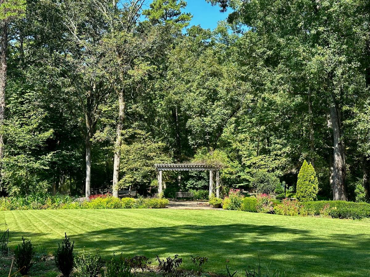 wood garden arbors arches with climbing roses and weathered cedar posts set into leveled gravel foundation